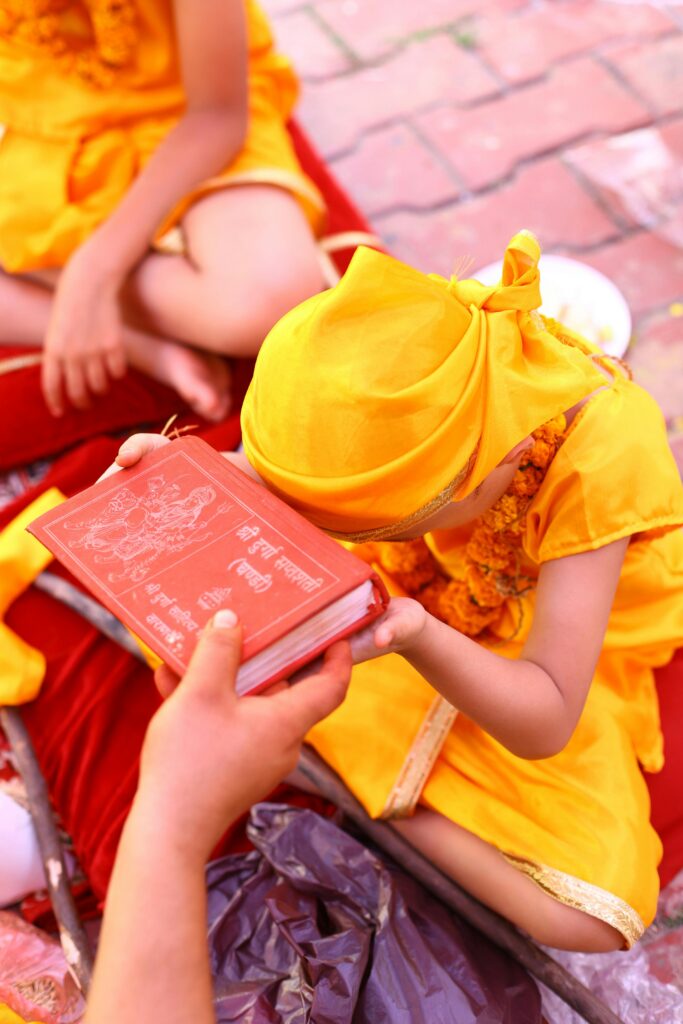 Child showing respect to a book during cultural ceremony.